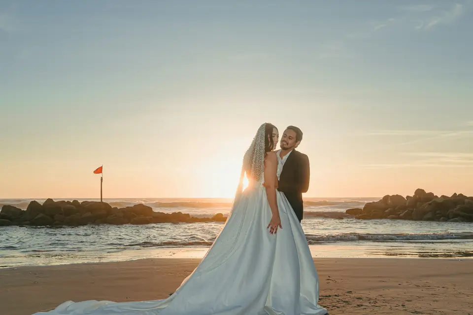 A couple on a beach with the sun on the horizon, the hour the brand is named for